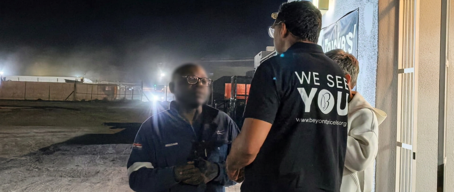 The We See You team talking with a driver outside the hub